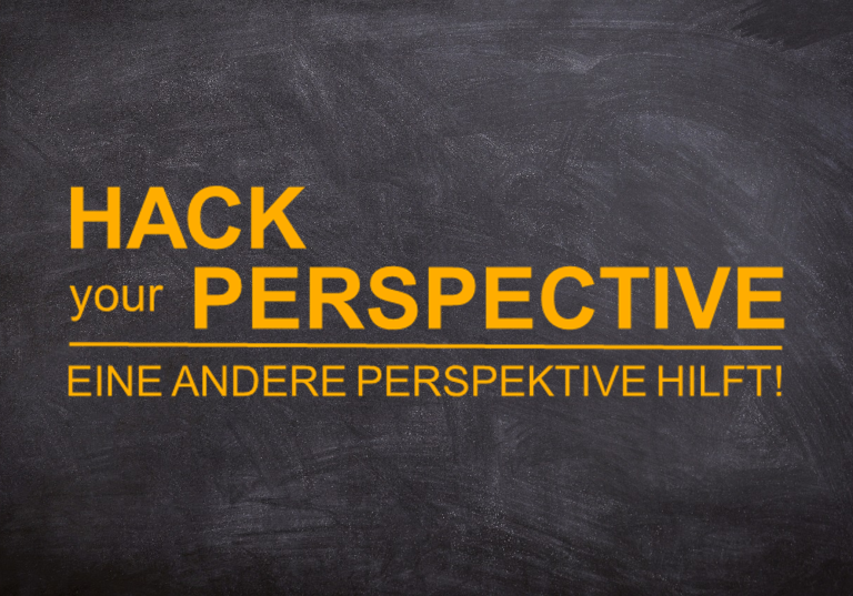Hack your perspective! Schwarze Tafel mit dem Text „Hack your Perspective“ und „Eine andere Perspektive hilft!“