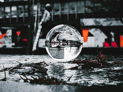 Job Beruf Eine reflektierende Glaskugel auf einem schmutzigen Boden mit verschwommenem Hintergrund.